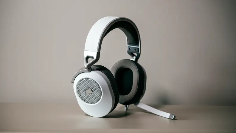 A pair of white headphones against a beige backdrop