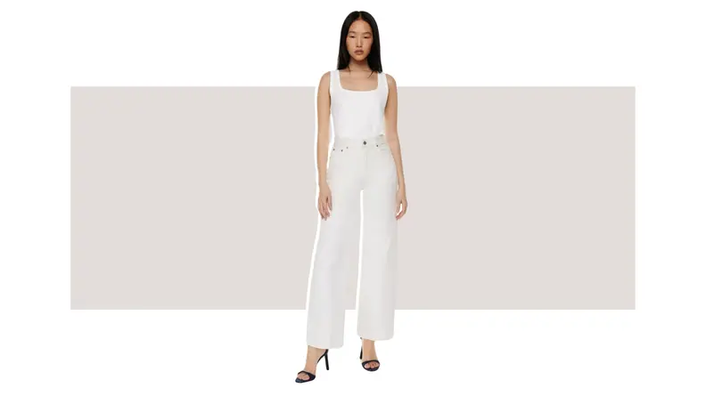 A model wearing a pair of white high-waisted wide-leg jeans.