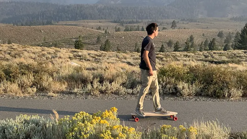 A boy rides the Magneto Hana Short Pintail Longboard