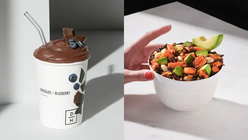On left, Blueberry Chocolate smoothie with straw. On right, hand grabbing for Daily Harvest veggie bowl.