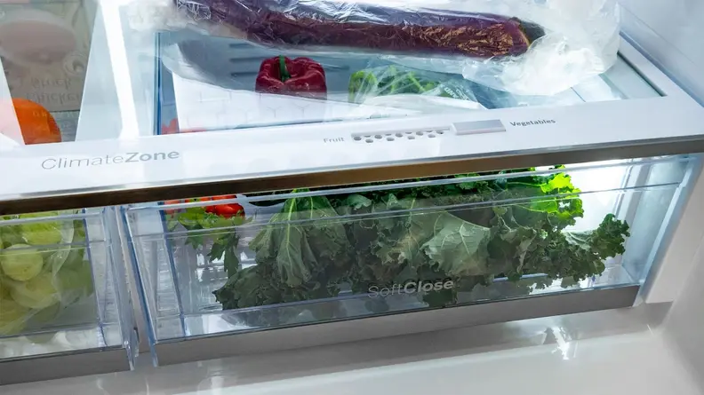 A close-up of the fridge's crisper drawers, stocked with fresh produce.