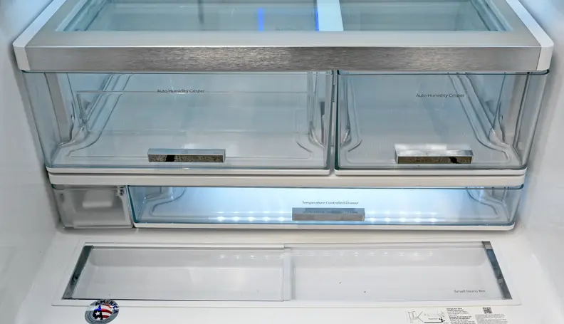 The fridge comes with asymmetrical crispers, a temperature adjust drawer underneath, and two recessed nooks right in front. The water filter is also found in the lower left corner.