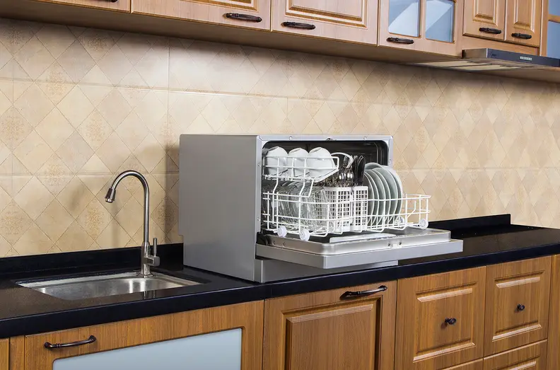 A countertop dishwasher sits atop a kitchen counter.