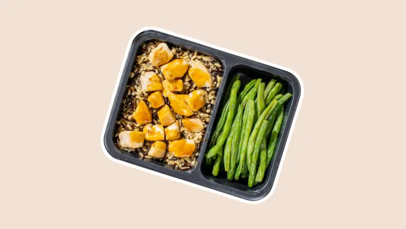 A Tempo meal shown in a two compartment container, one side filled with chicken and the other with a vegetable.