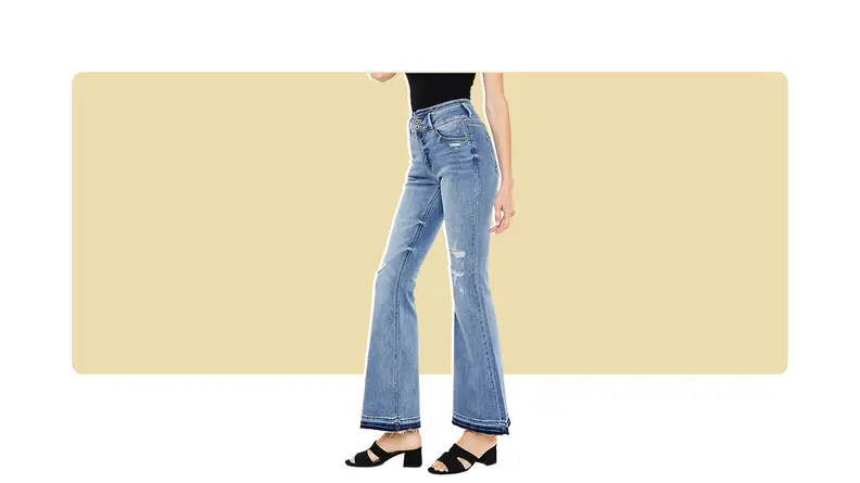 A model seen from the waist down, wearing flared jeans with black shoes.