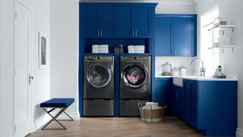 The Electrolux EFLS527UTT washer beside an Electrolux dryer in a blue laundry room.