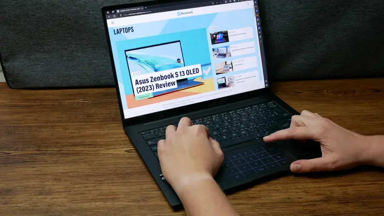 A pair of hands interacting with the Asus Zenbook 14x OLED.