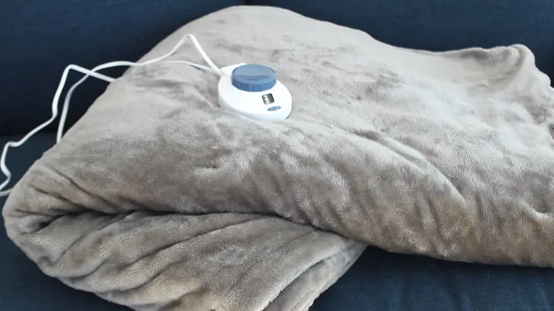 The Sleep Number electric blanket folded up on a couch.