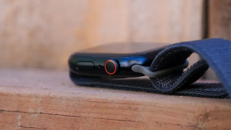 The Digital Crown and side button of the Apple Watch are visible in this photo.
