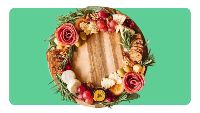 A cutting board with snacks making up a wreath on top.