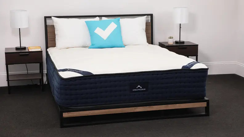 The Dreamcloud mattress in a bedroom between two bedside tables.