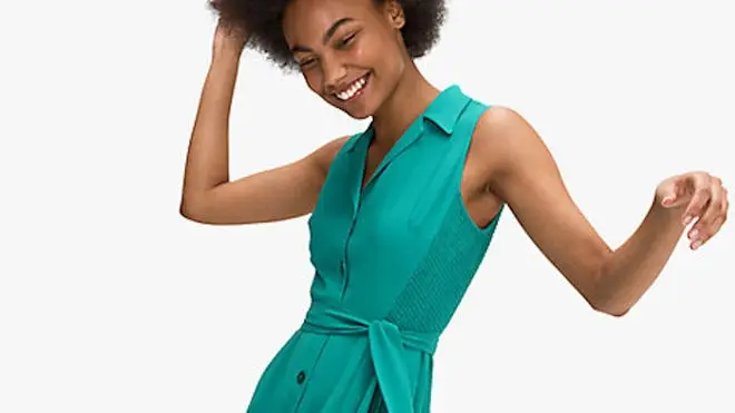 Woman smiling while wearing teal Kate Spade dress