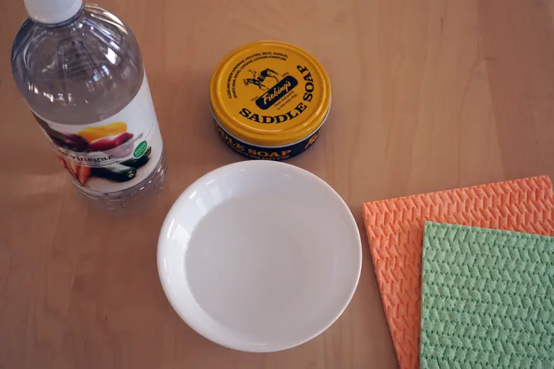 Water, vinegar, cloths, and saddle soap