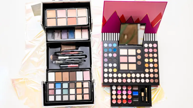 Two makeup kits sitting side by side open to reveal makeup.