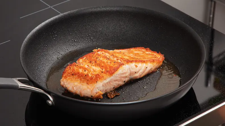 Salmon cooking on the Circulon ScratchDefense pan.