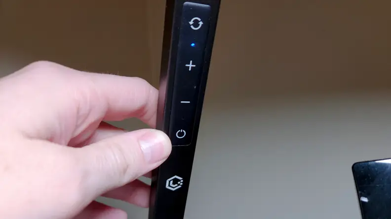 An LED Light from Lume Cube with a hand posed next to the controls