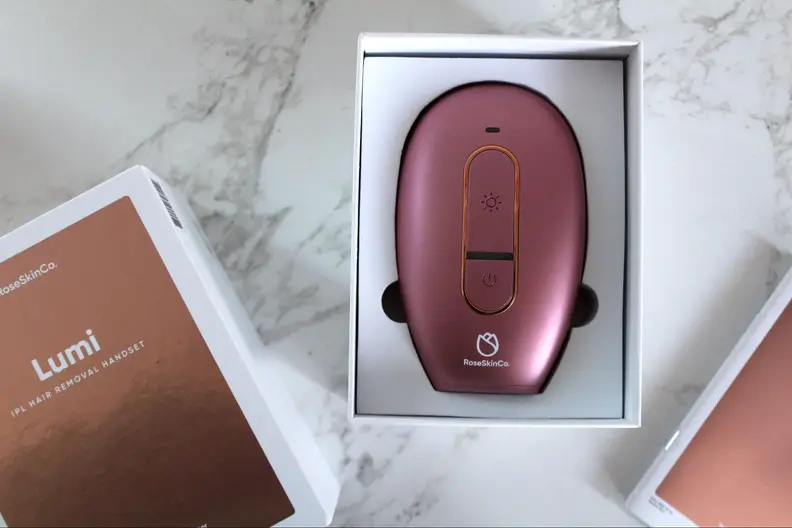 A pink RoseSkinCo. Lumi permanent hair removal device in its packaging.