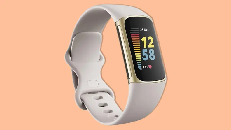 A Fitbit Charge 5 smartwatch with a tan silicone band on an orange background.