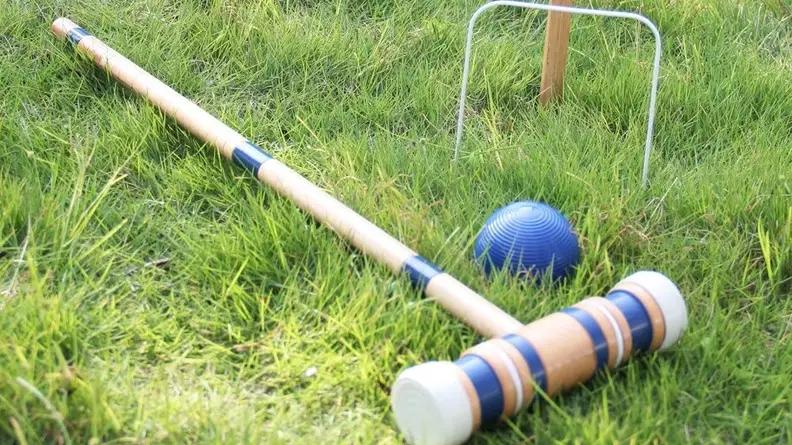 Close up of a croquet mallet and ball.