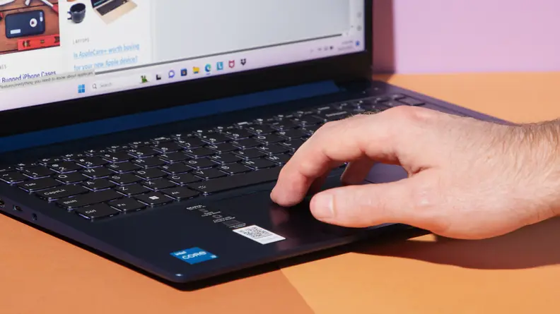 A person's hand  using the trackpad on a laptop.