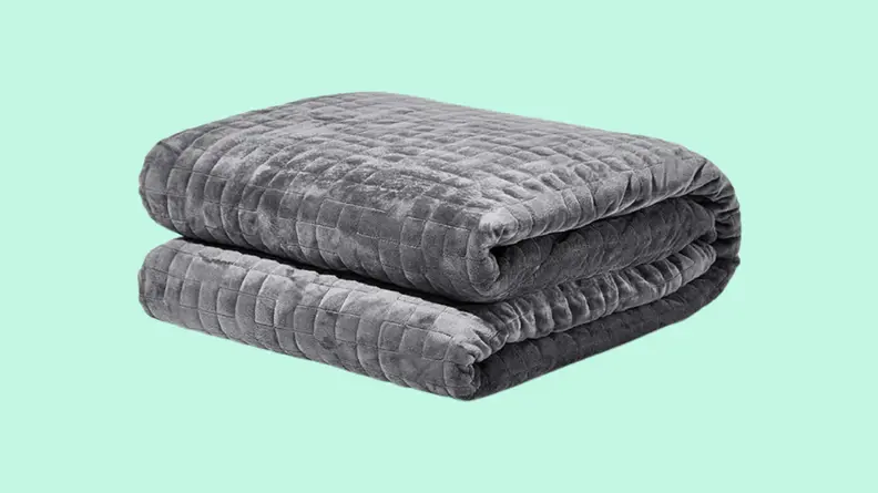 Folded weighted blanket against blue background