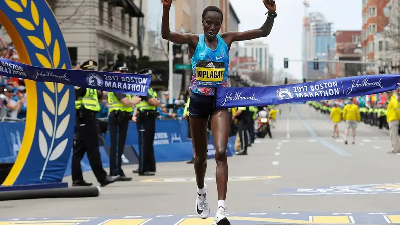 Edna Kiplagat crossing the finish line in first place in her pair of Nike Zoom Vaporfly 4%s at the 2017 Boston Marathon..