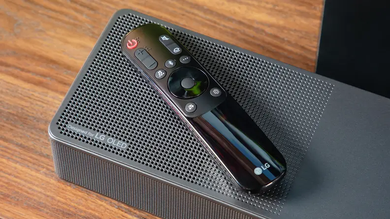 The corner of the LG SC9S soundbar with the LG remote sitting on top of it.