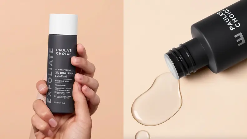 On the left: Two hands hold up the gray bottle of Paula’s Choice Skin Perfecting 2% BHA Liquid Exfoliant against a peach background. On the right: The Paula’s Choice Skin Perfecting 2% BHA Liquid Exfoliant lays on a cream background with liquid spilling out of it.