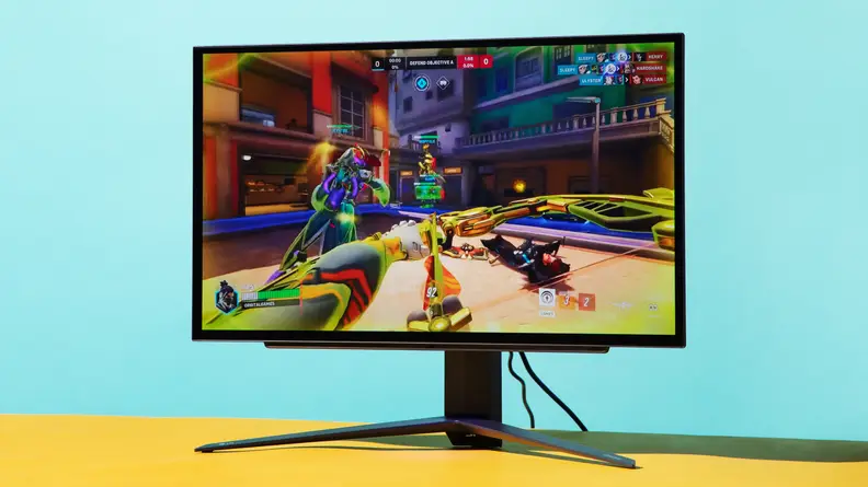 LG UltraGear OLED 27GR95QE-B gaming monitor on top of yellow desk.