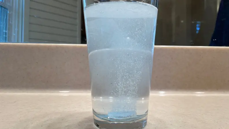 A glass of water with a foaming retainer cleaner solution