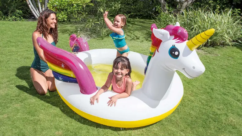 A family playing in a unicorn-shaped pool