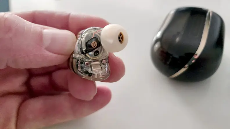 A person holds an earbud