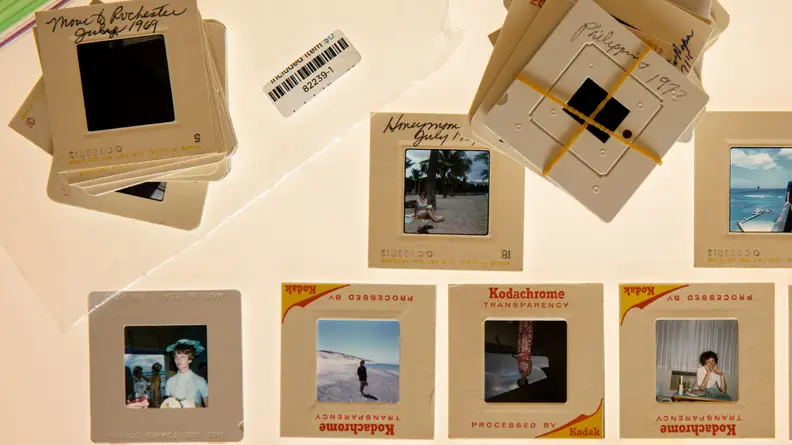Several stacks of old photo slides labeled with dates and places.