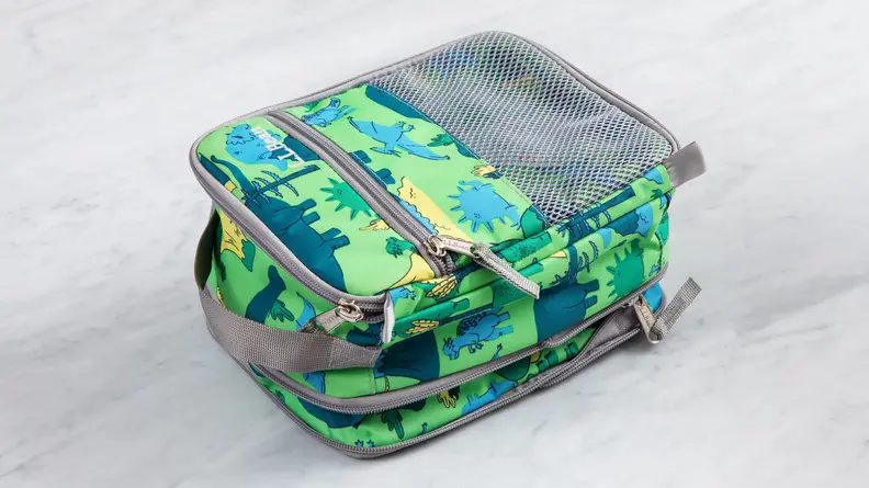 The L.L. Bean Expandable Lunch Box in green dinosaur print on a marble counter.