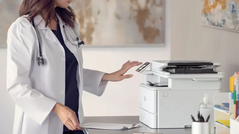 A healthcare worker using the touchscreen on an HP LaserJet Pro 4101fdw.
