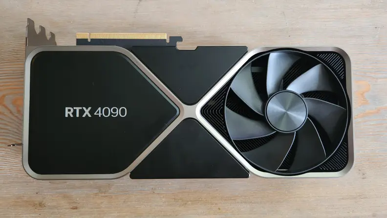A black and silver graphics card lying flat on a wooden table.