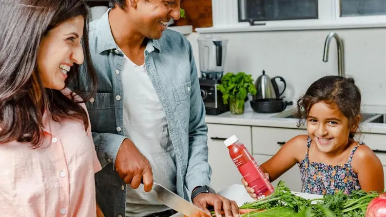 Smiling family preparing food together.