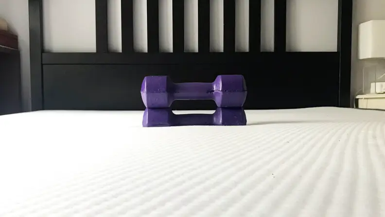 A mattress has a weight on it.