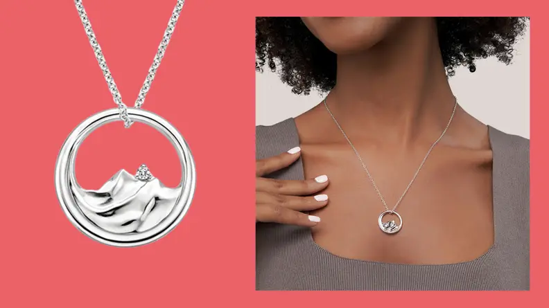 A cloose up of a silver Brilliant Earth Mountain Range diamond pendant on a silver necklace.