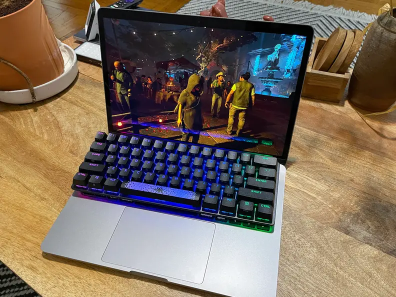 A photo of a small black keyboard placed on top of the keyboard of an open laptop
