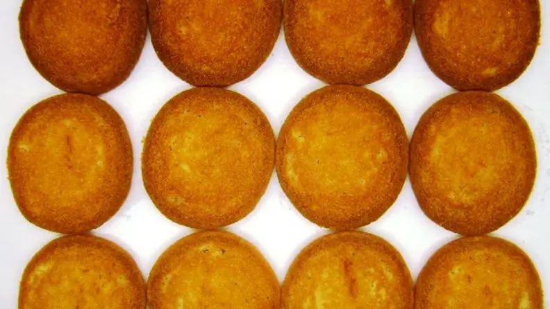 The underside of twelve sugar cookies arranged in three straight rows.