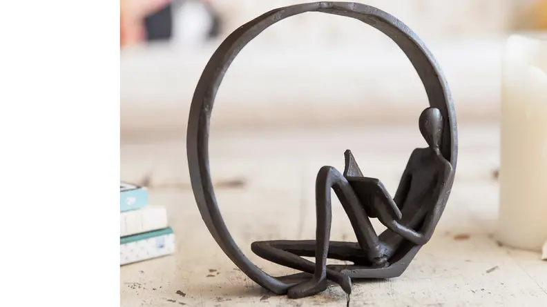 Cast iron statue of a figure reading