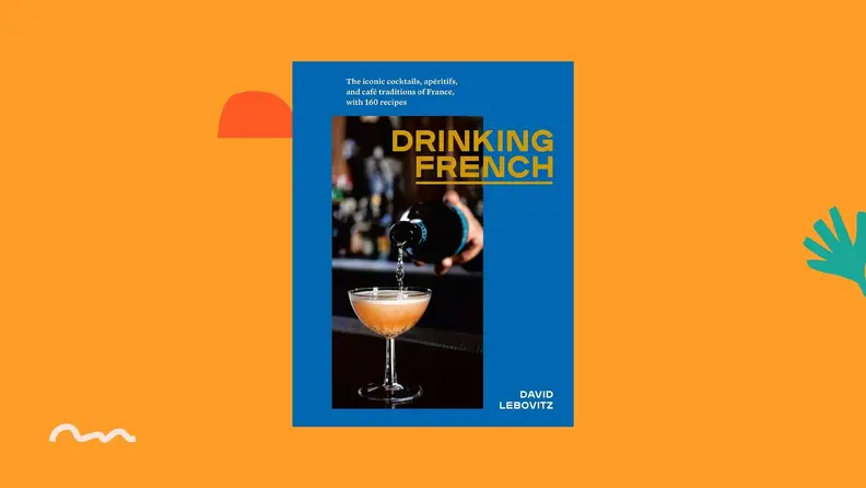 Drinking French cookbook against a bright orange background.