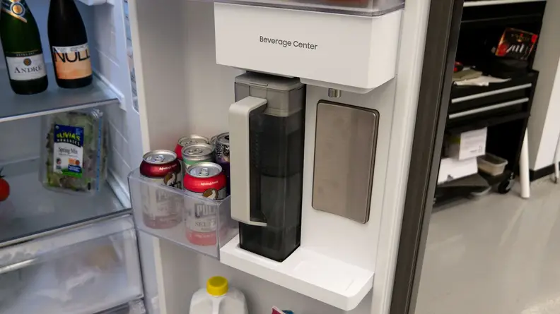 Gray auto-refilling water pitcher placed into the beverage center in the door of the Samsung RS28CB7600 side-by-side Bespoke refrigerator.