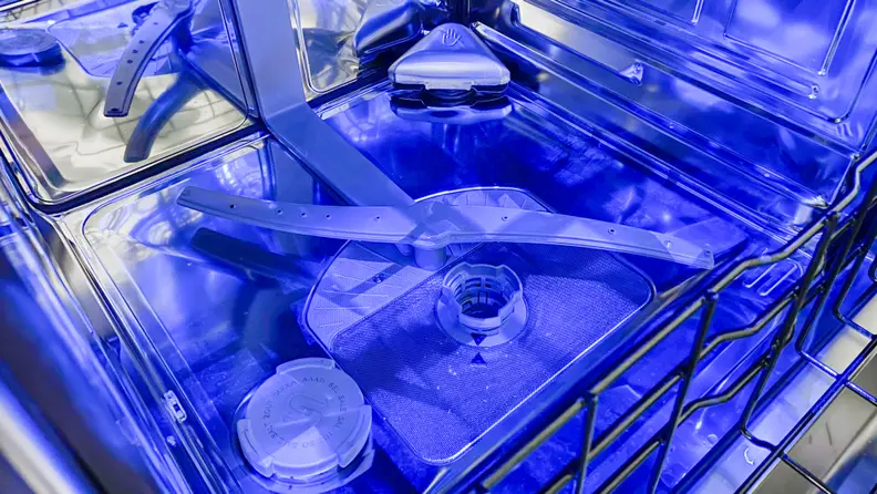 A shot of the base of the Thermador DWHD770WFM dishwasher's interior, with a small compartment in the back right-hand corner for zeolite.