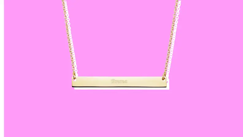 A Brilliant Earth Horizontal Bar Pendant on a pink background.