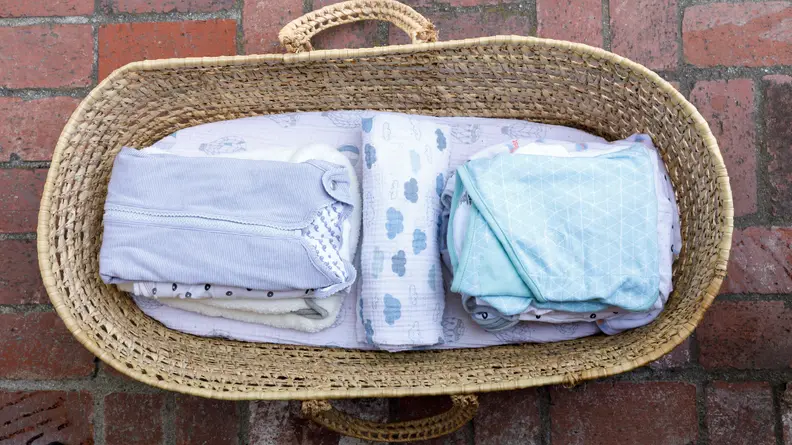 A moses basket filled with baby swaddles