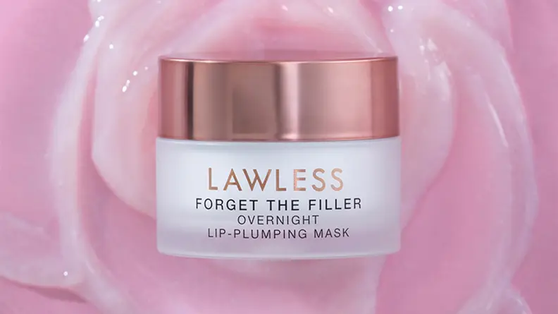 A small white and gold jar of lip mask with a creamy pink texture behind the jar.