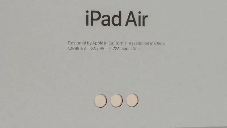 A closeup of a Space Grey iPad Air's pogo pins