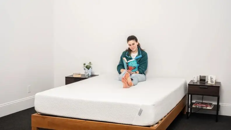 A person sitting on a bed reading a book.